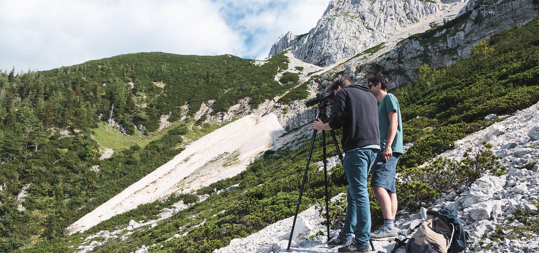 Zwei Männer fotografieren einen Berg.